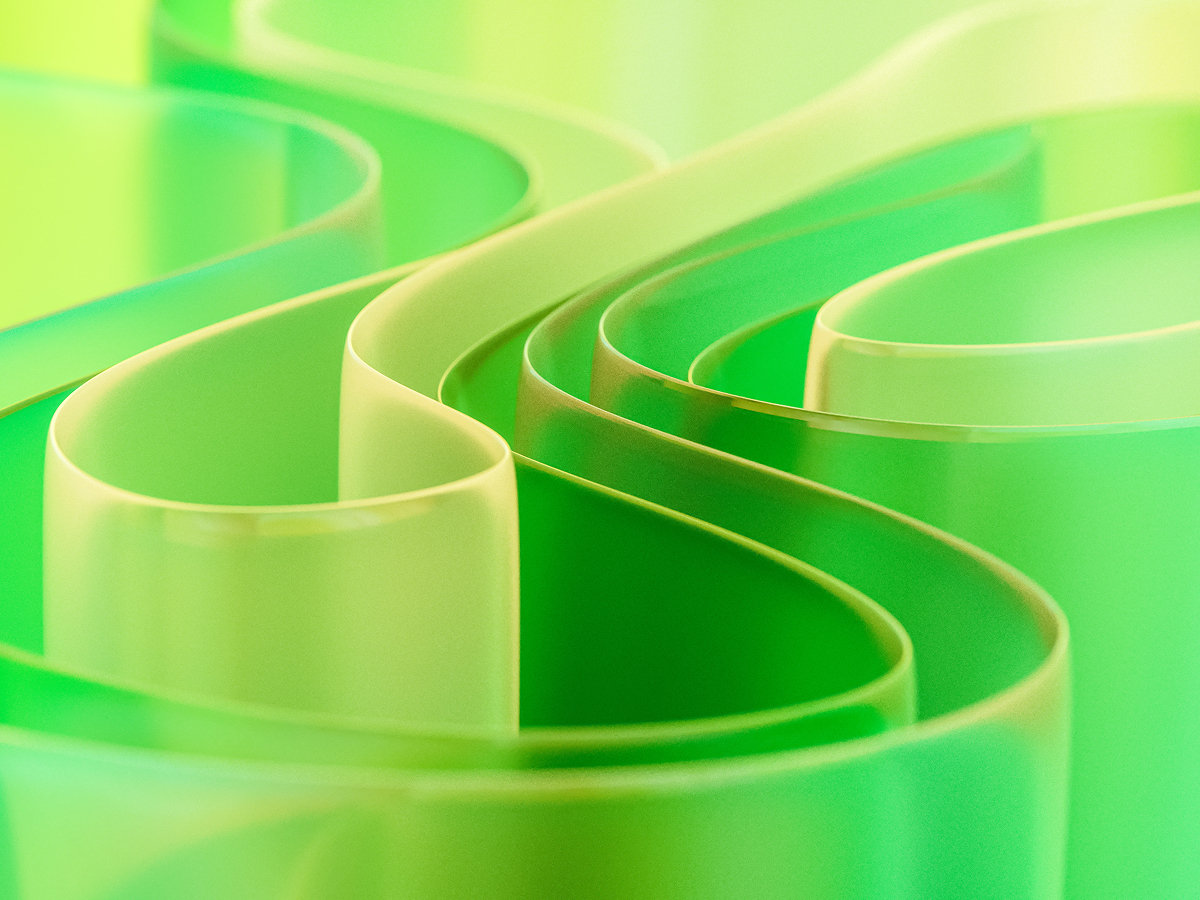 Abstract green translucent ribbons flowing in S-curves with a glossy glass-like finish and bokeh.